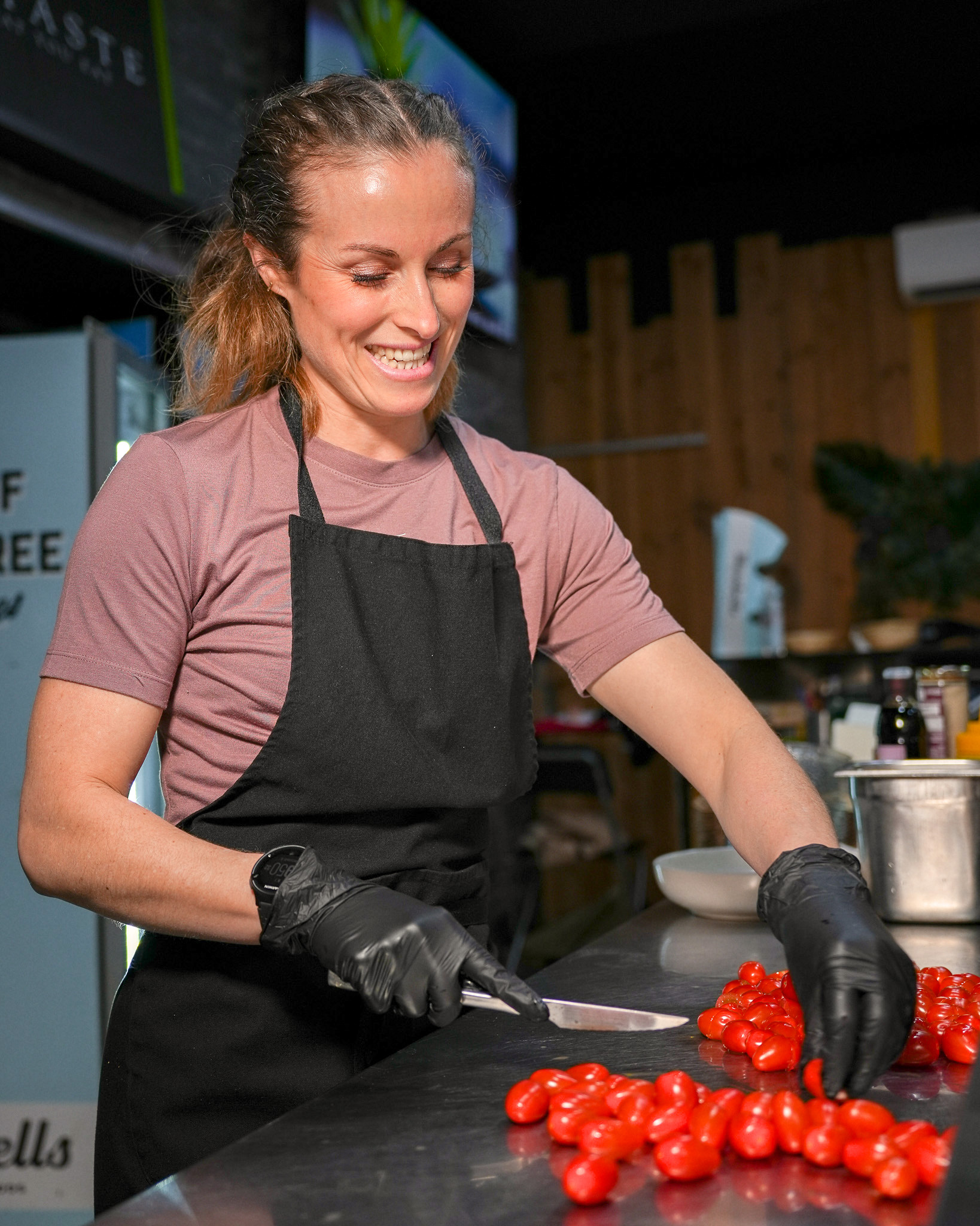 Une cuisinière de Pure Taste coupe des tomates cerises en cuisine